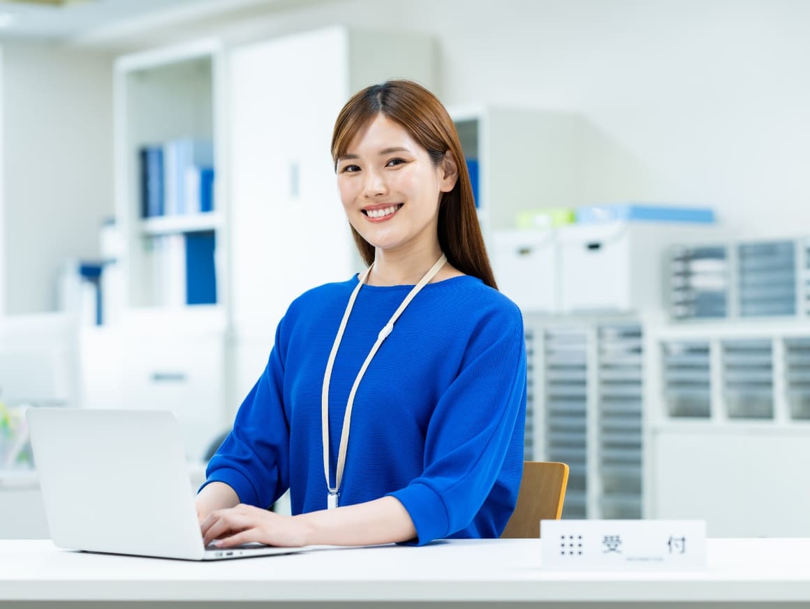 パソコンの前に座っている女性の写真