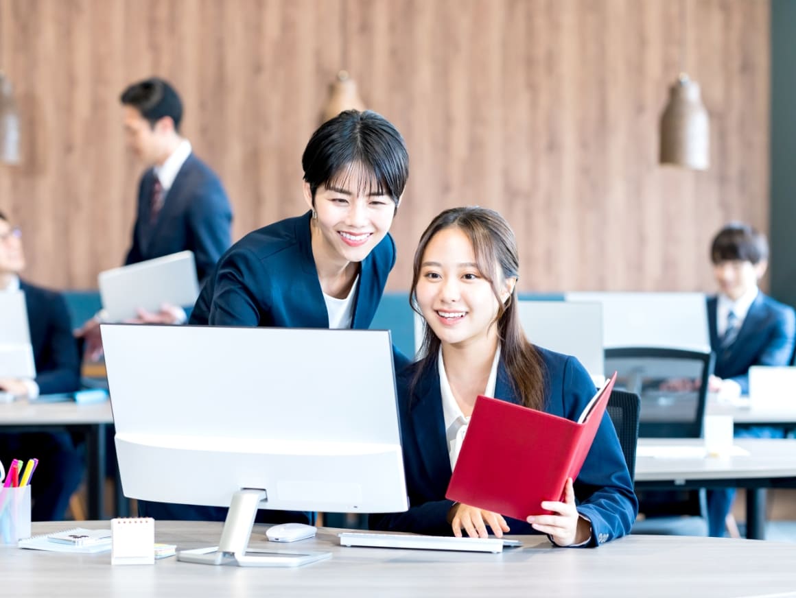 パソコンを教えている女性と確認している女性の写真
